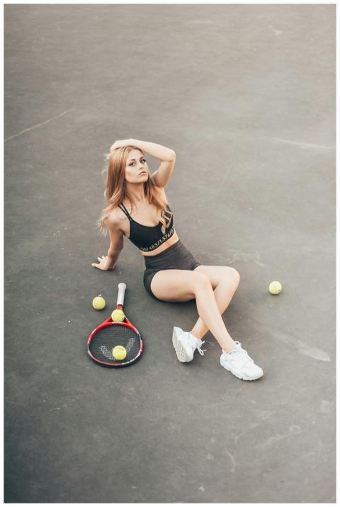Elegant woman posing on a tennis court with racket