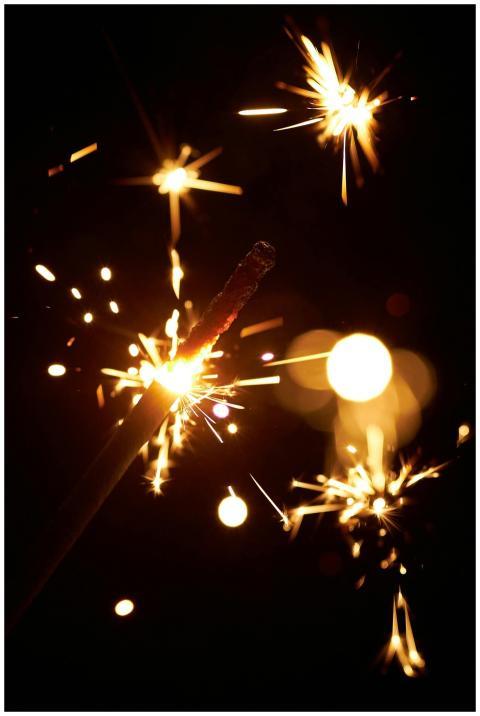 Dazzling close-up of a lit sparkler on a black bac