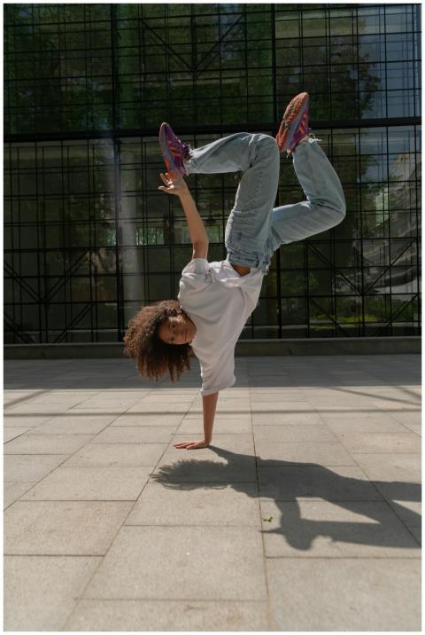 Energetic dancer in white shirt and jeans doing a