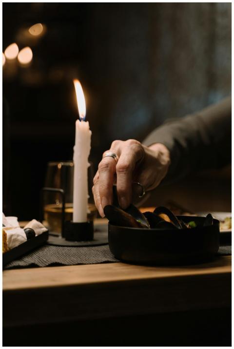 Intimate dining setting with mussels and candlelig