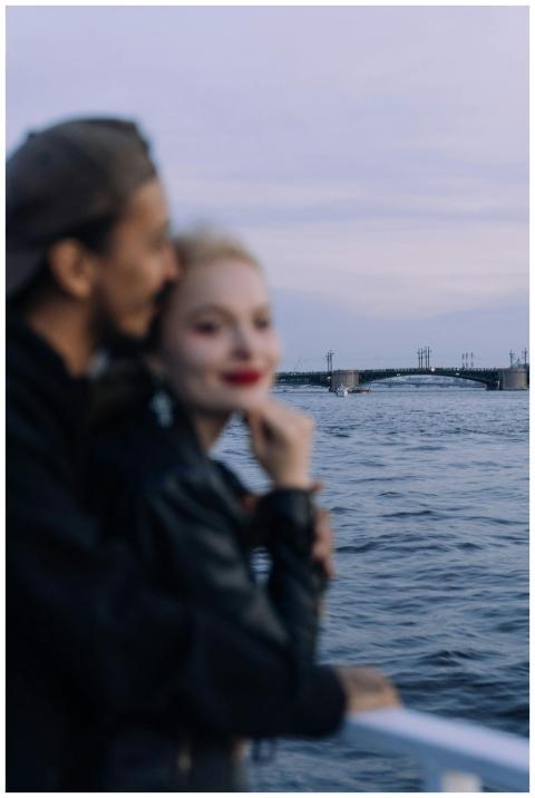 A couple embraces on a boat, enjoying a serene eve
