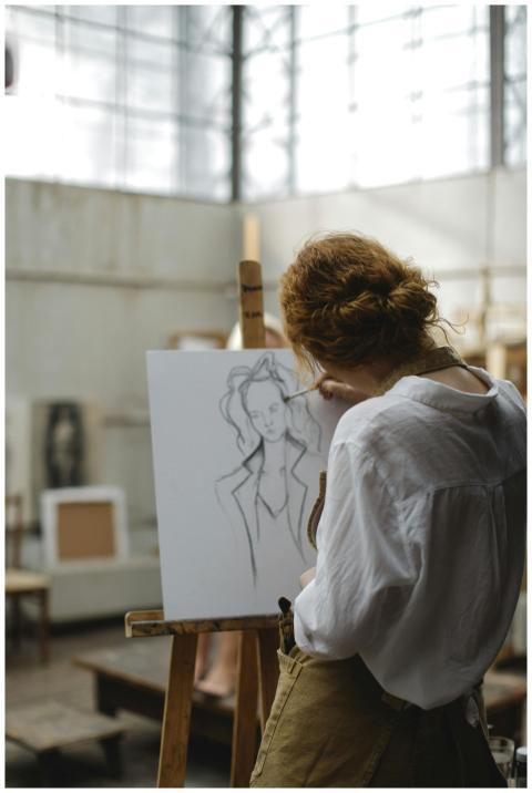 A young woman focuses intently as she sketches on