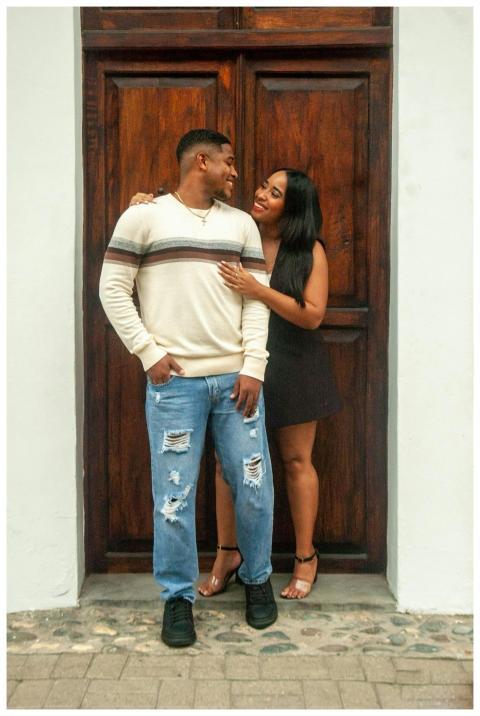 Smiling couple standing close, embracing in front