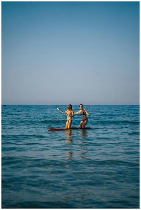 Two women paddleboarding on a sunny day in Vietnam