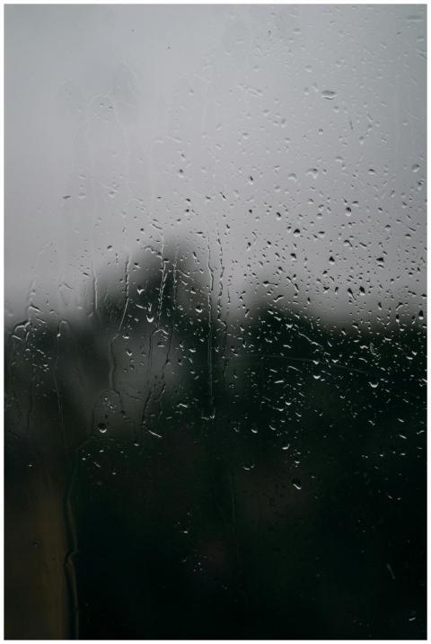 Close-up of raindrops on a window with a blurred v
