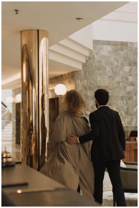 A couple walking in a luxurious hotel lobby, showc