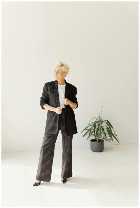 Stylish woman in a pinstripe suit poses in a minim