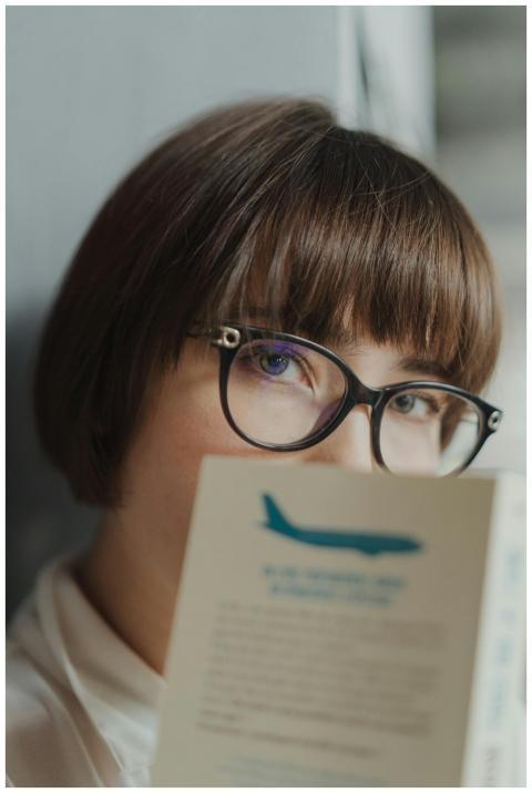 Portrait of a woman with glasses peering over a bo