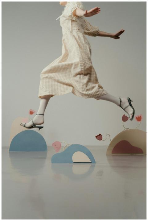 Woman in a vintage dress jumping gracefully indoor