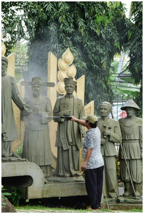 A man carefully cleans a series of historical stat