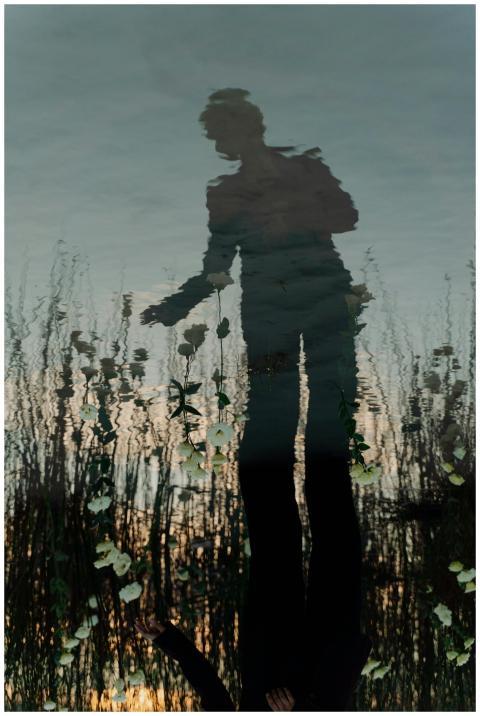 Artistic reflection in water with flowers and silh