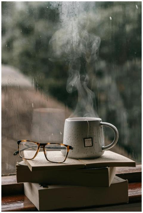 Comforting setup with books, glasses, and hot tea