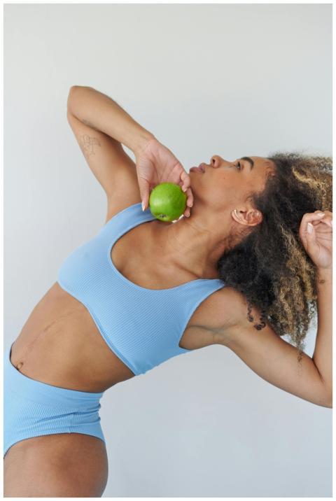 A woman in blue activewear performing a stretch wh