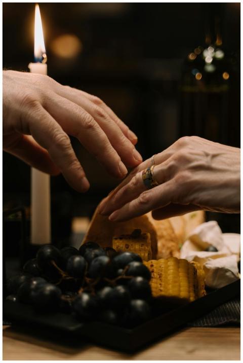 Close-up of hands touching over a romantic candlel