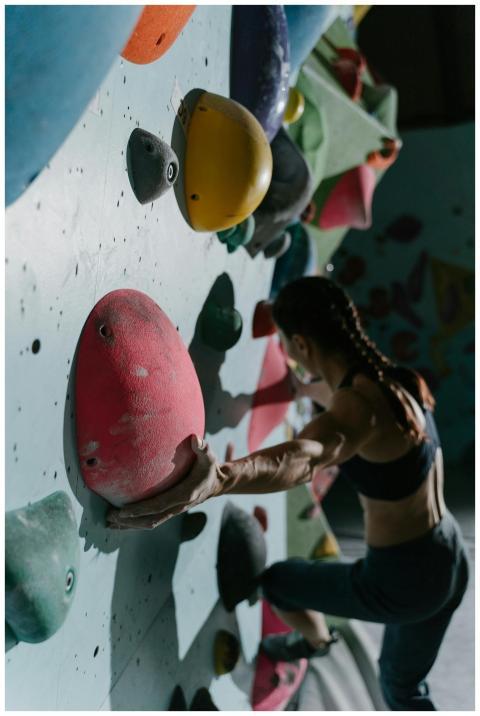 A woman engaged in bouldering on a challenging ind