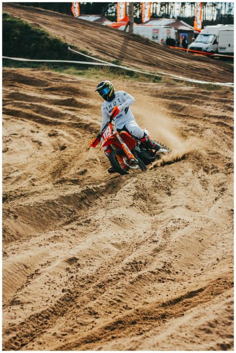 Dynamic motocross racer speeding through a dirt tr