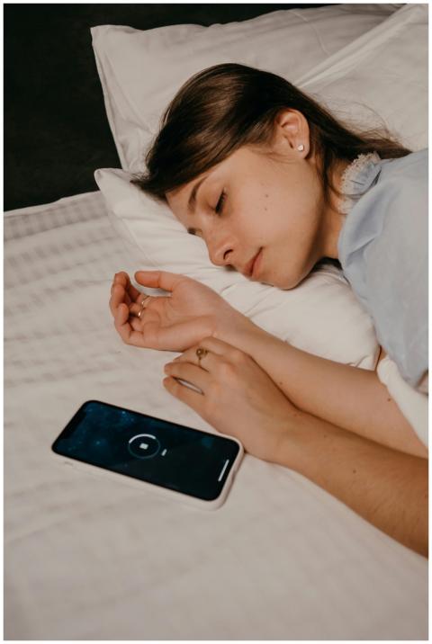 A woman sleeping peacefully with a smartphone on t