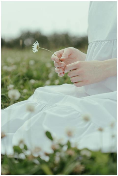 Close-up of a woman in a white dress holding a cha