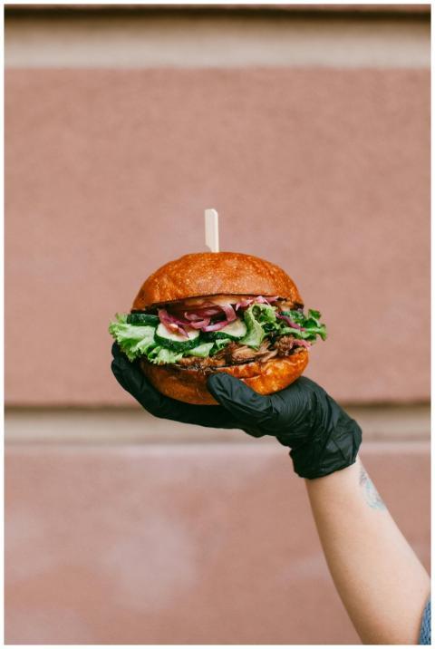 A juicy gourmet burger with fresh toppings held by