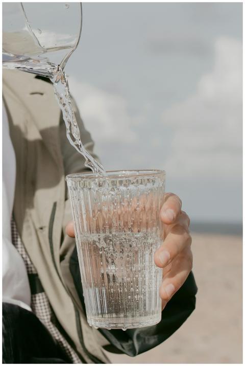 Close-up of water being poured into a glass hand-h