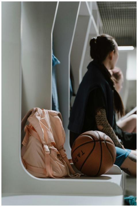 A female basketball player sitting in a locker roo