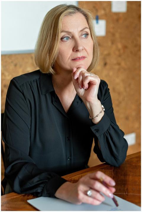 Mature businesswoman in black attire thinking at a