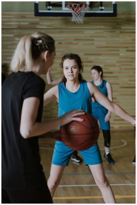 Women engaged in a competitive basketball game ind