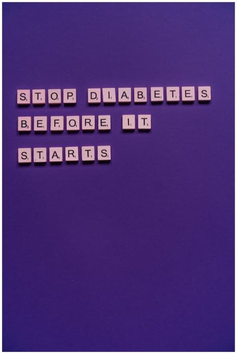 Scrabble tiles on purple background spell 'Stop Di