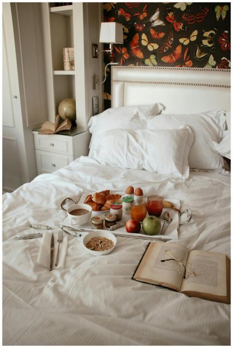 A cozy breakfast in bed with croissants, coffee, a