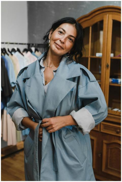 Woman in a stylish blue trench coat shopping in a
