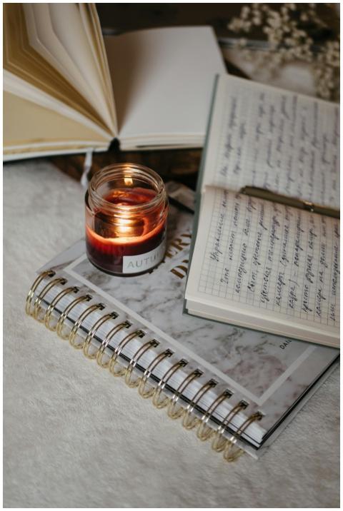 A warm candlelight scene with open journals and ha