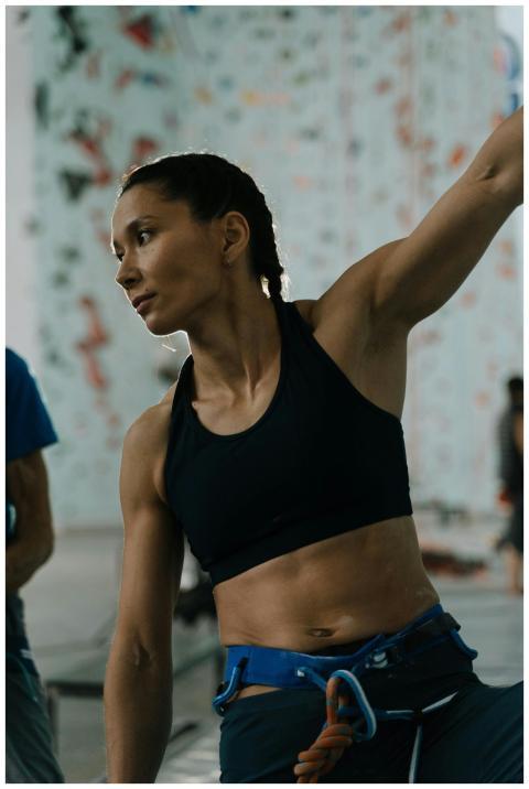 Athletic woman in climbing gym preparing for ascen