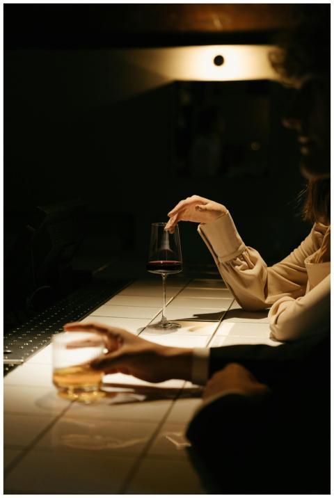 Two people enjoying drinks at a dimly lit bar coun