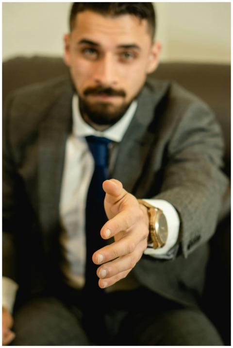 Close-up of a businessman in a suit extending hand