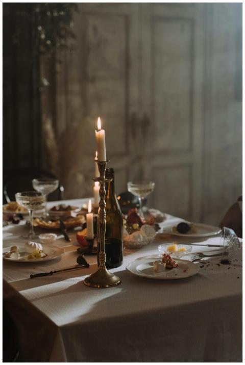 A dimly lit table set with leftover plates and can