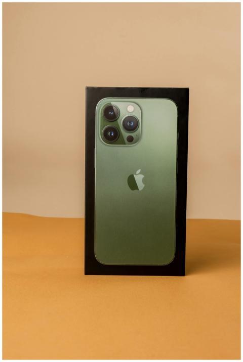 A vertical shot of a green smartphone box with a n