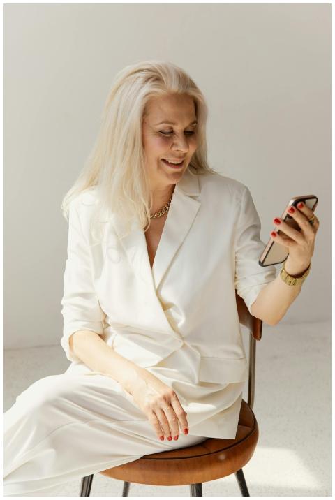A stylish senior woman in white business attire us