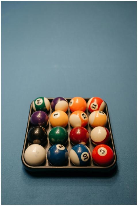 Vividly colored billiard balls neatly arranged on