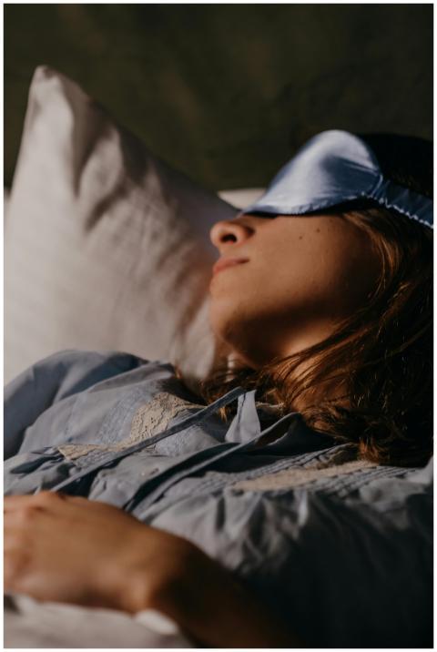 A woman resting peacefully in bed with a blue eye