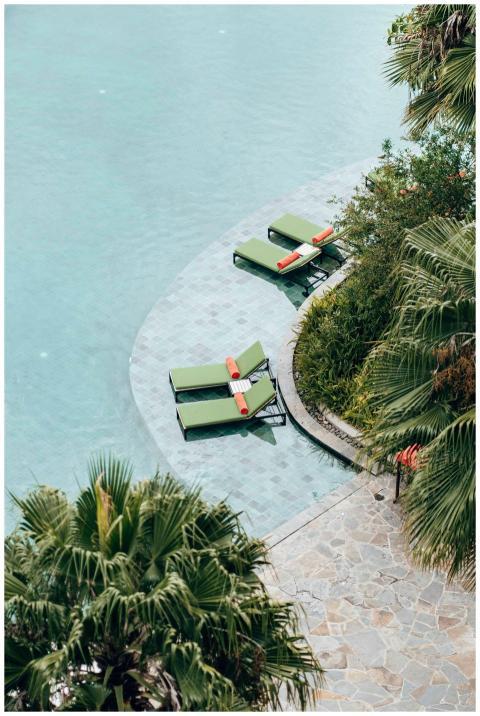 Relaxing poolside scene with lounge chairs and pal