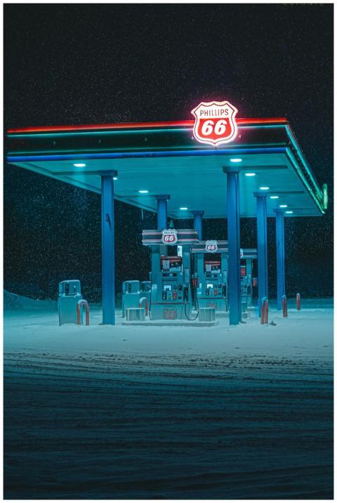 A vibrant neon-lit gas station amidst a snowy land