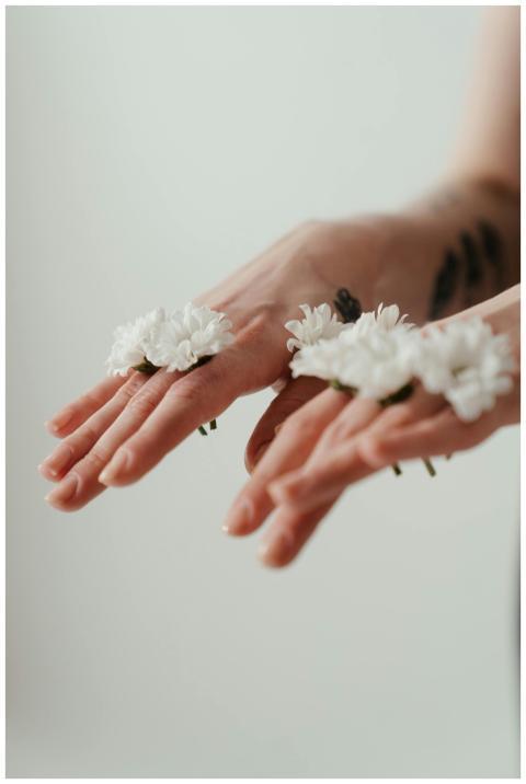 A minimalist photo of hands with white chrysanthem