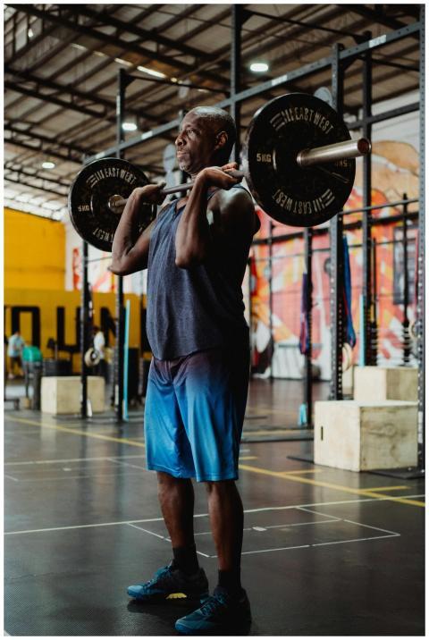A man lifts weights in an indoor gym setting, focu