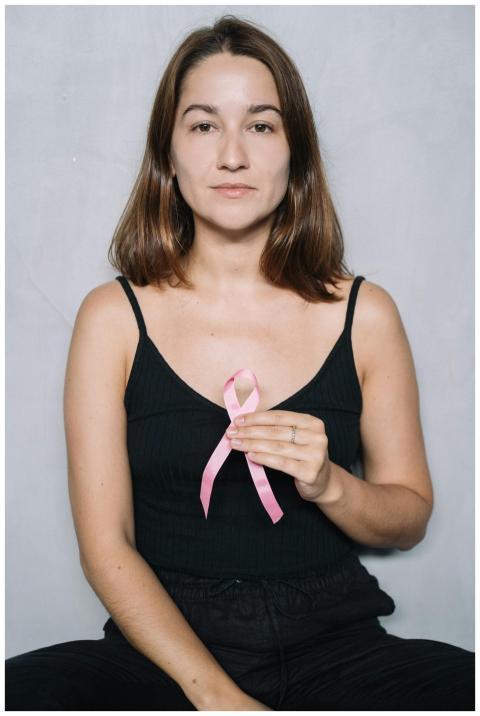 Young woman promoting breast cancer awareness by h
