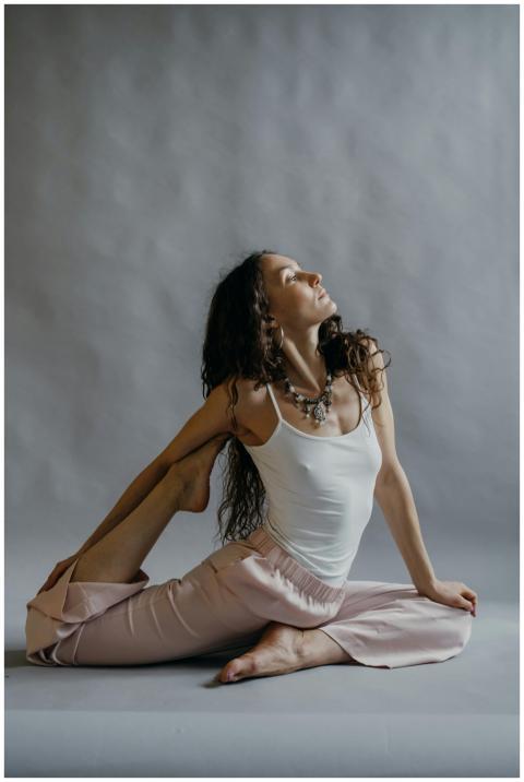A woman practicing yoga in a studio, displaying fl