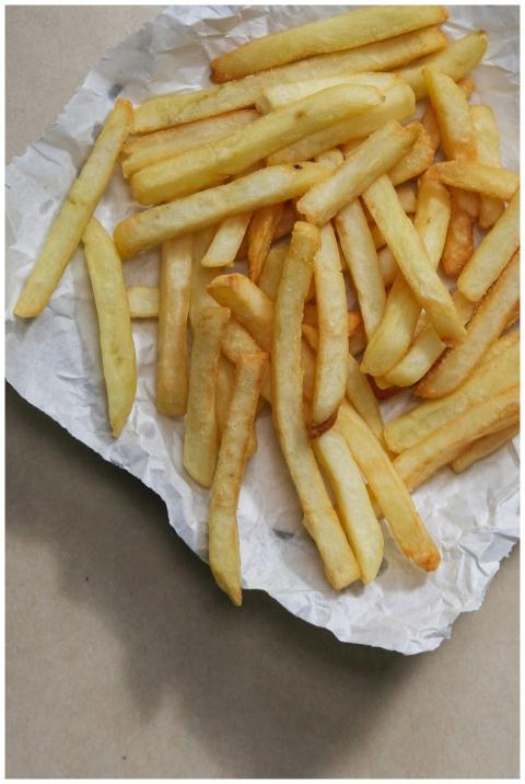 Close-up of golden french fries on crumpled paper,