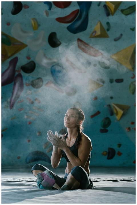 A woman rock climber prepping with chalk powder in