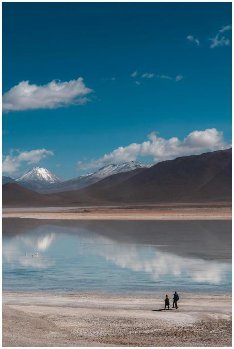 Two people walk across the famous Uyuni Salt Flats
