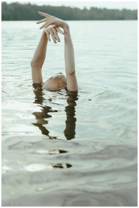A person's arms reaching out of the water in a cal