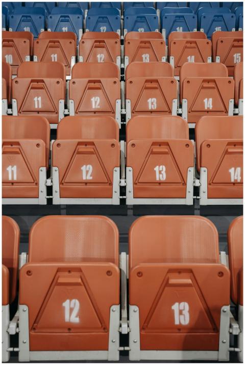 Close-up of orange and blue numbered stadium seats